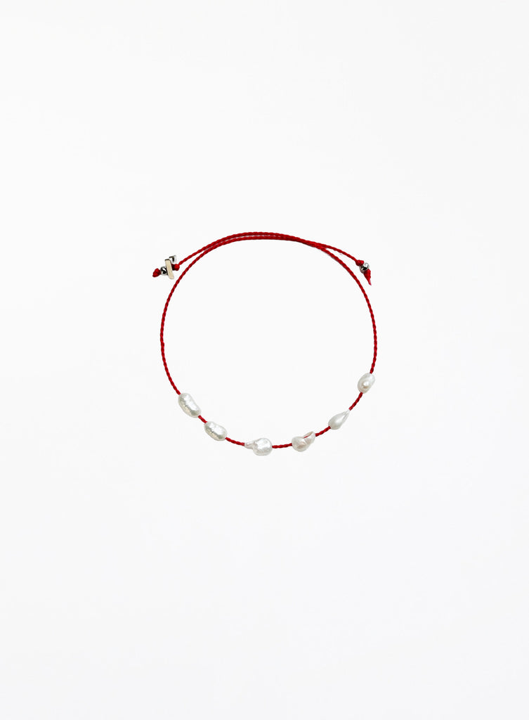Red bracelet with pearls on a white background