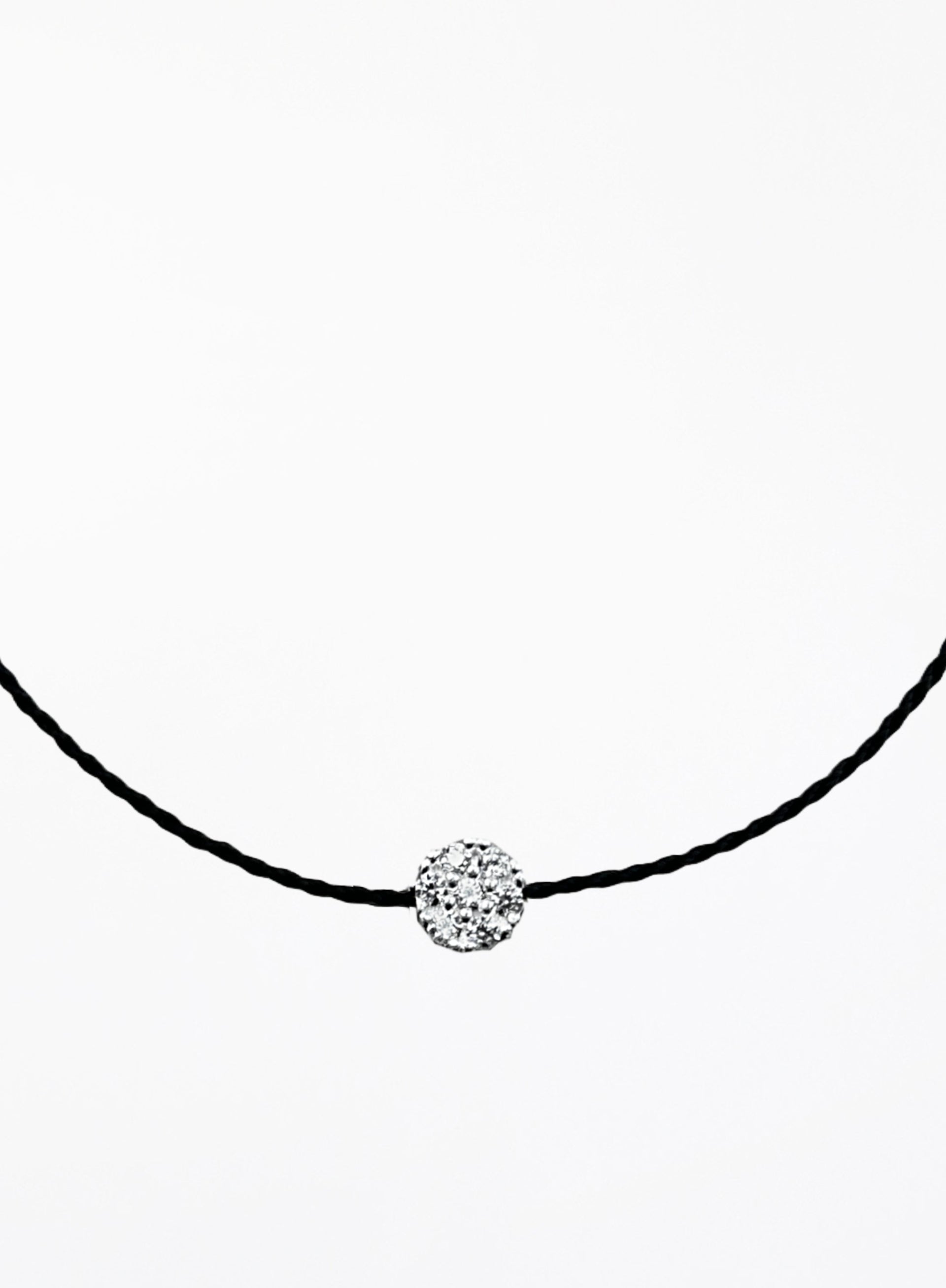 Black bracelet with a round crystal pendant on a white background