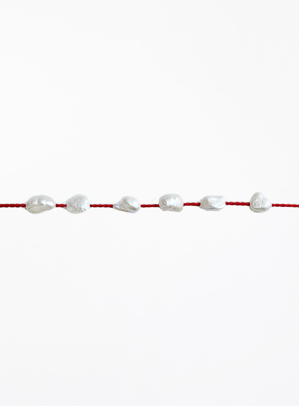 Red bracelet with pearls on a white background