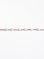 Red bracelet with pearls on a white background
