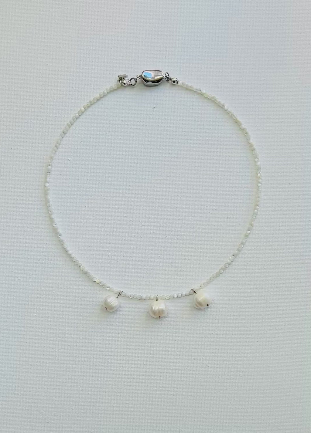 Necklace with three cultured pearl beads on a white background