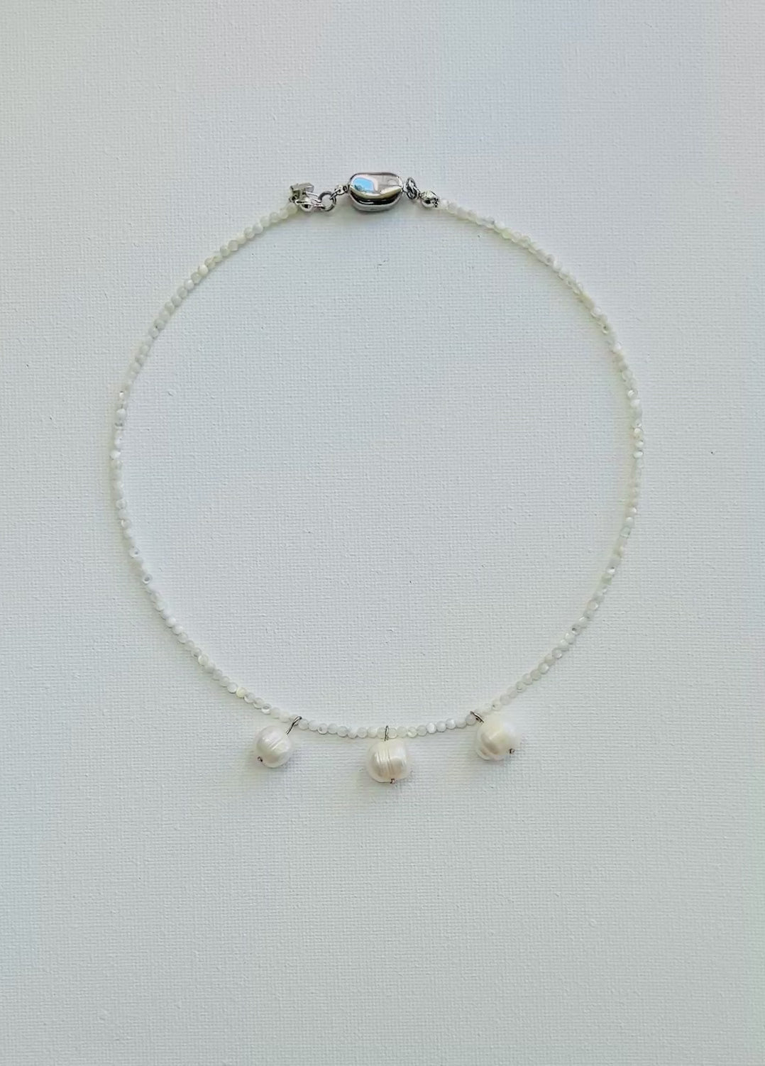 Necklace with three cultured pearl beads on a white background