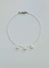 Necklace with three cultured pearl beads on a white background
