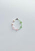 Beaded bracelet with pearls and green pink  stones on a white background