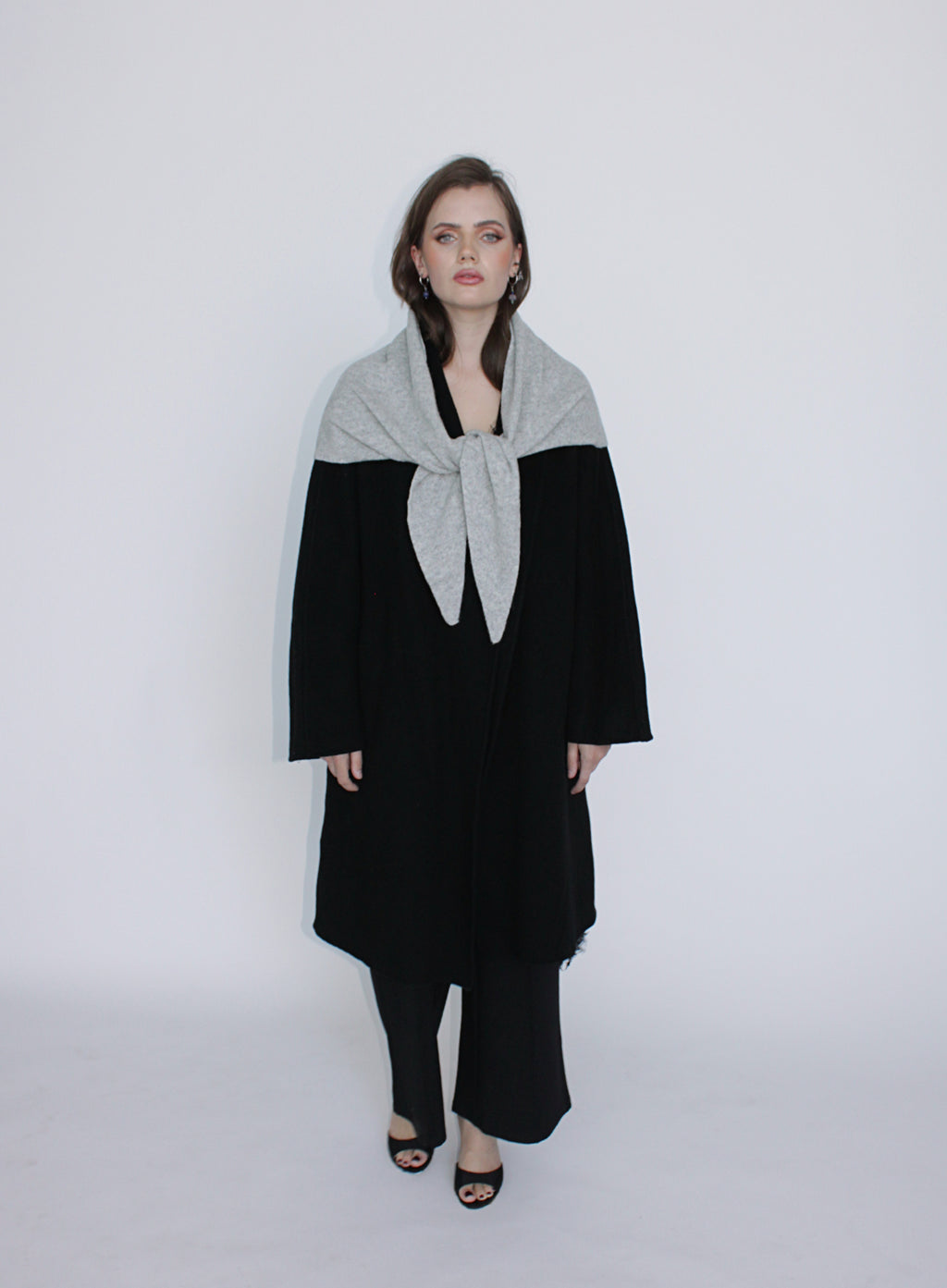Woman wearing a black and gray outfit with a scarf on a white background
