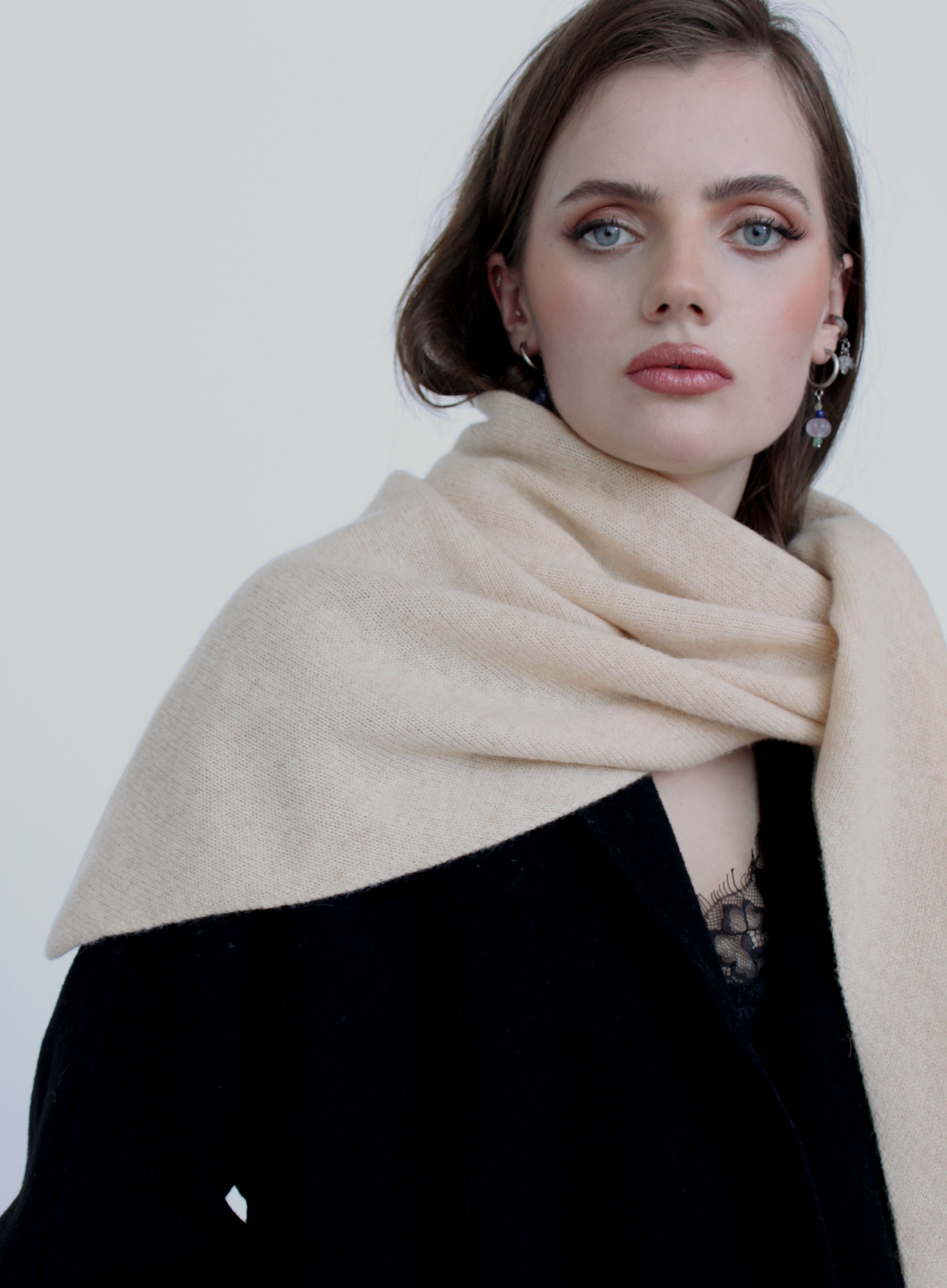 Woman wearing a beige scarf against a white background