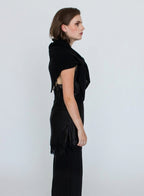 Woman wearing a black shawl over a black dress against a white background