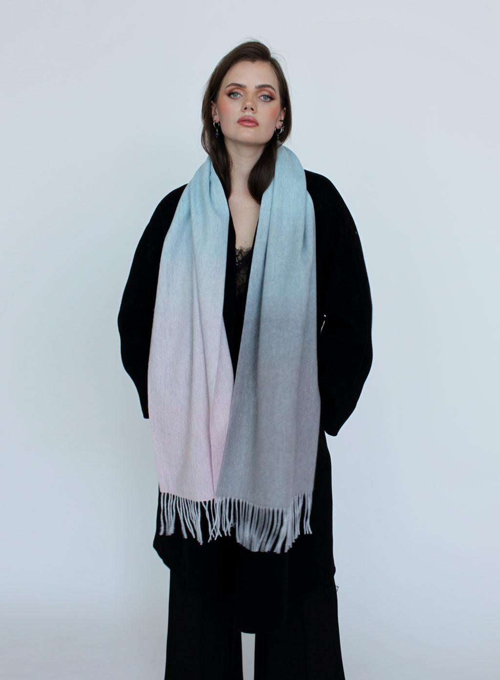 Woman wearing a gradient scarf on a plain background