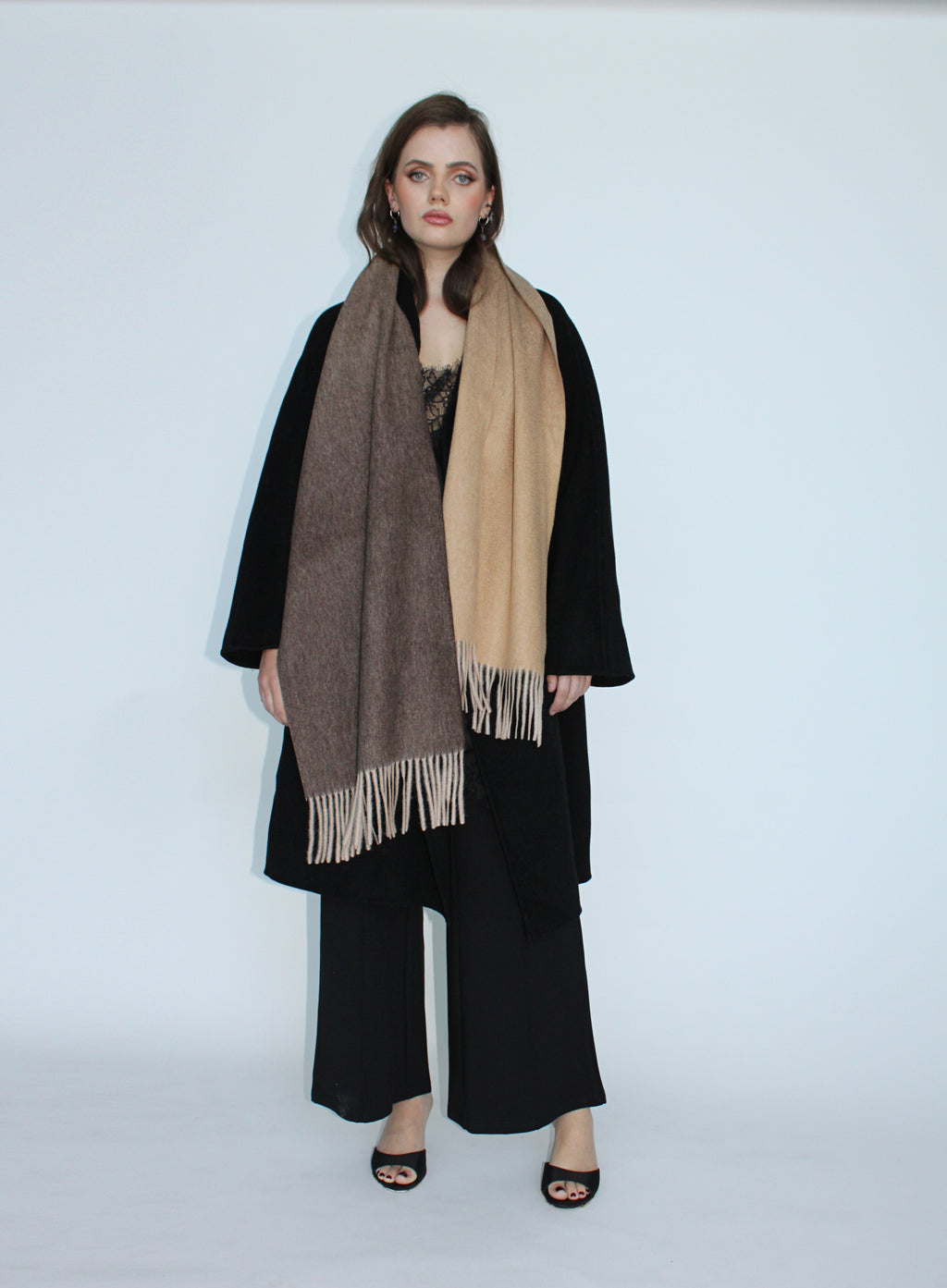 Woman wearing a black coat and scarf on a white background