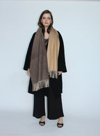 Woman wearing a black coat and scarf on a white background