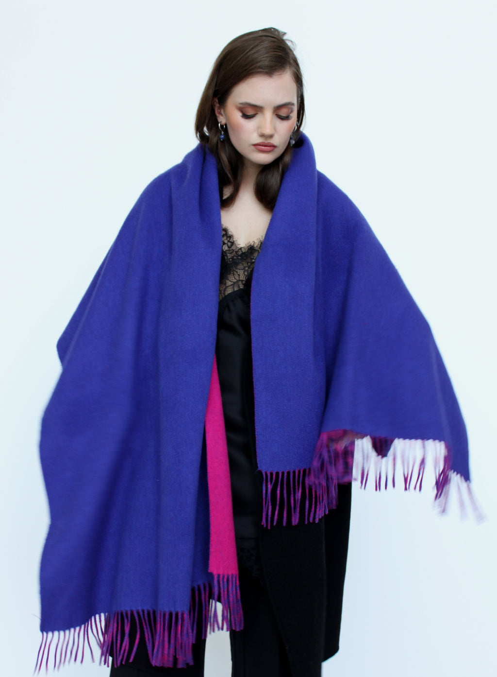 Woman wearing a large blue and pink scarf on a white background