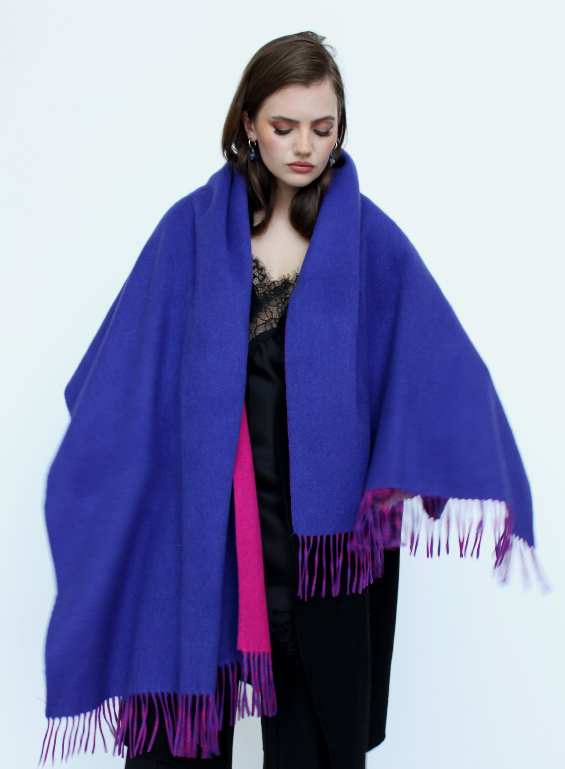Woman wearing a large blue and pink scarf on a white background