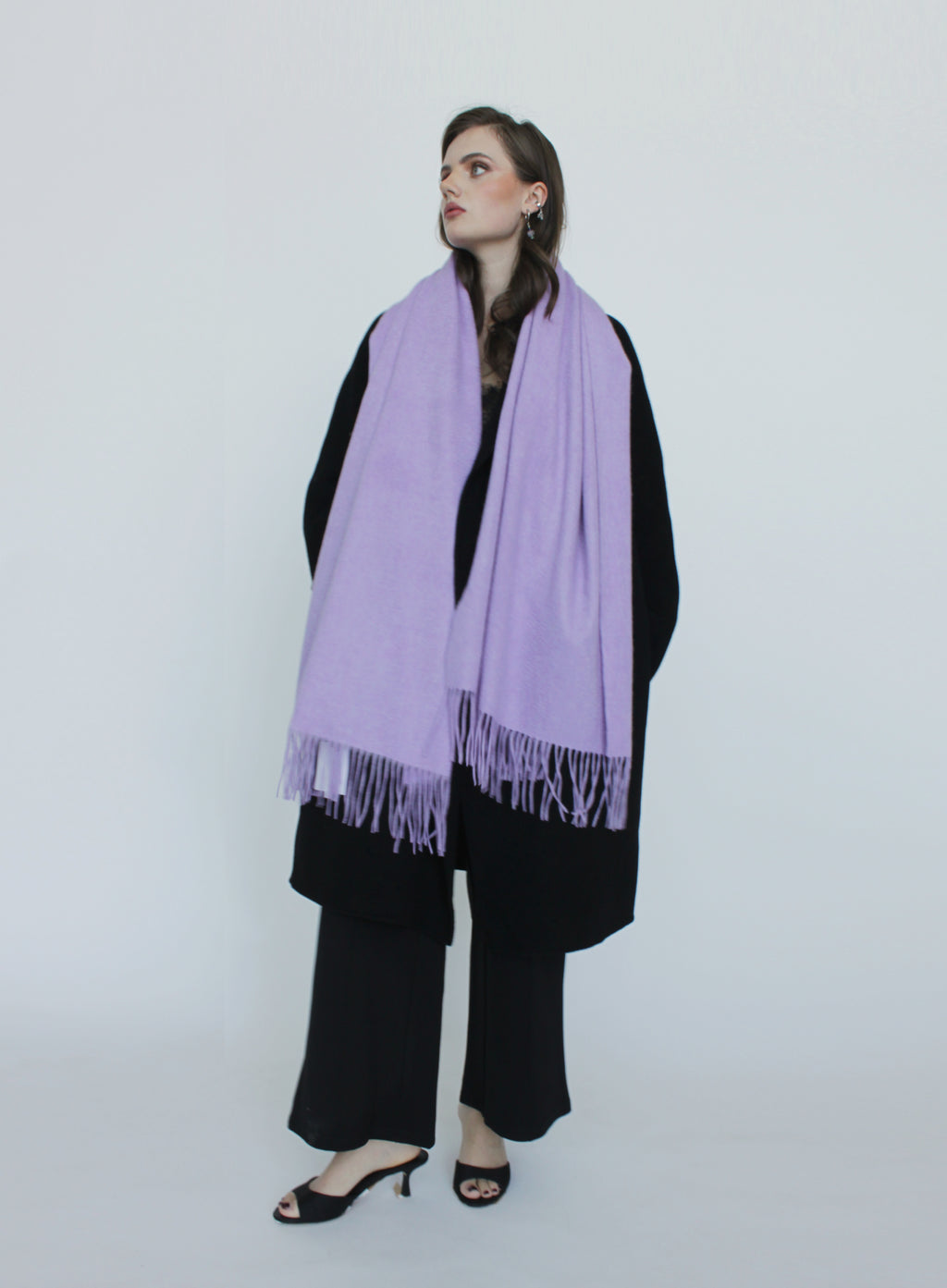 Woman wearing a purple scarf and black outfit on a white background