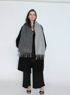 Woman wearing a gray scarf and black outfit on a white background