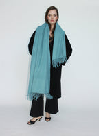 Woman wearing a light blue scarf on a white background
