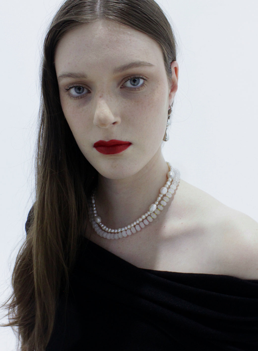 Woman wearing a pearl necklace against a white background