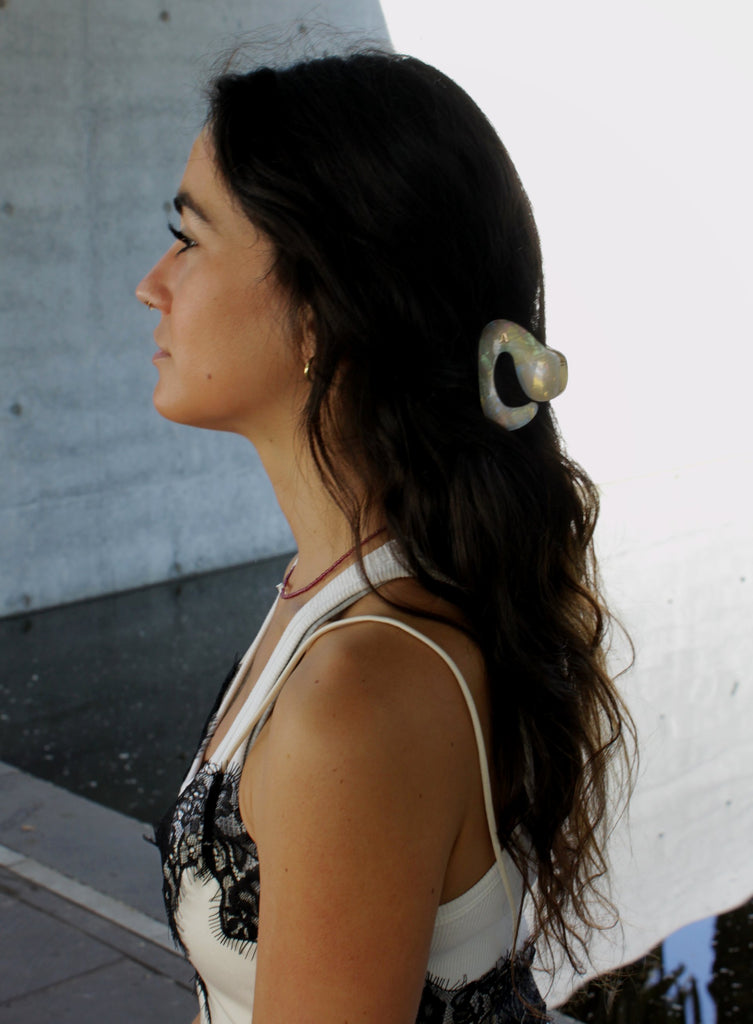 Woman with a hair clip against a light-colored wall
