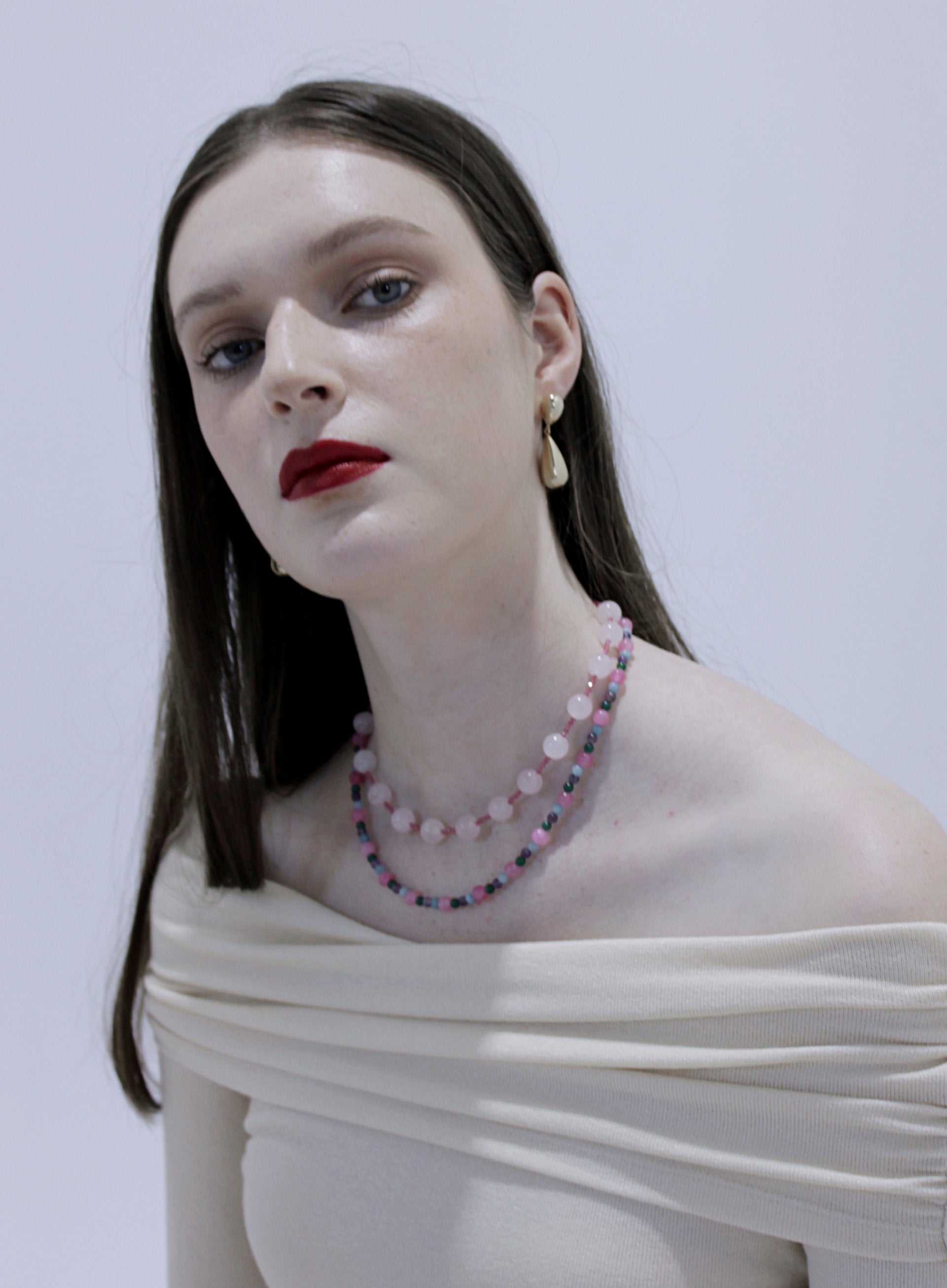 Woman wearing a beaded necklace with gold earrings