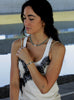 Woman wearing a white tank top with blue beaded pearl necklace and bracelet