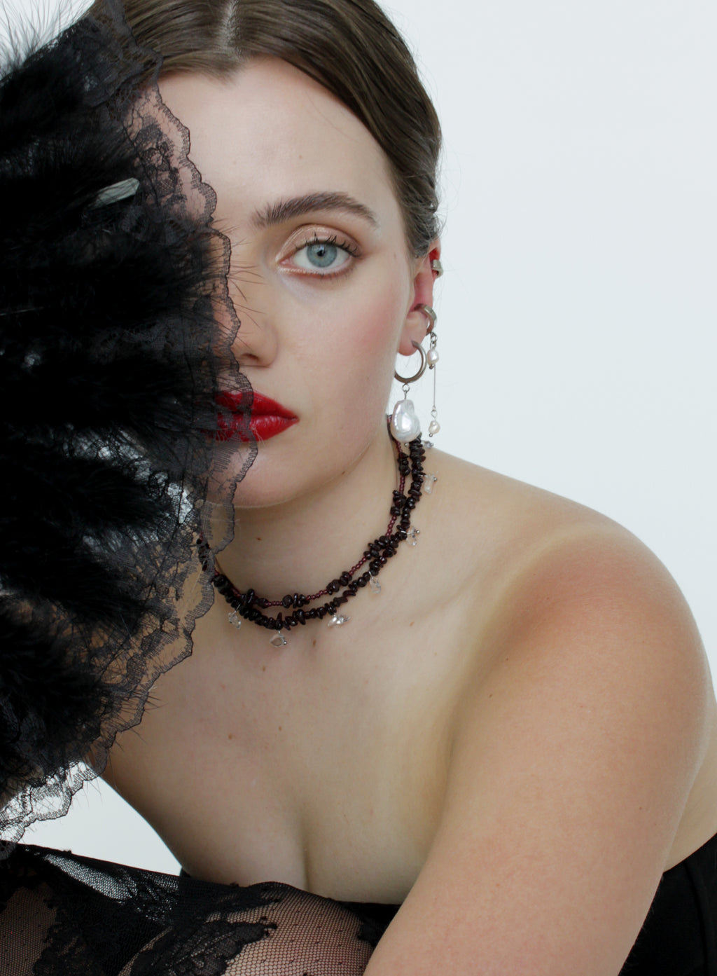 Woman wearing a black lace garment with a white background