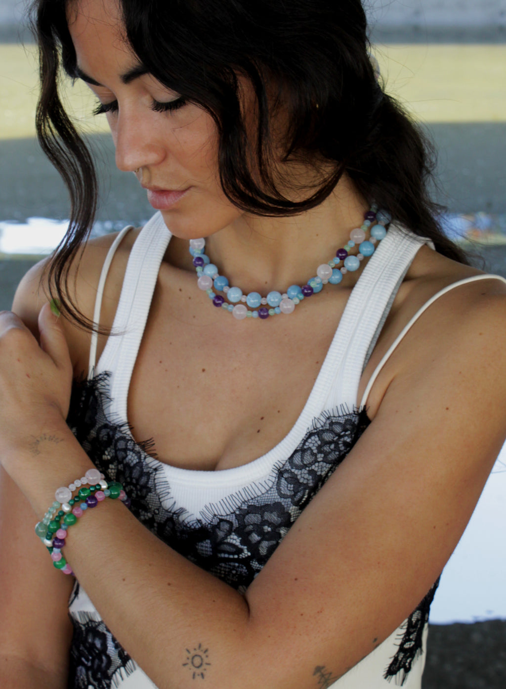 Woman wearing a necklaces and bracelets with a blurred background
