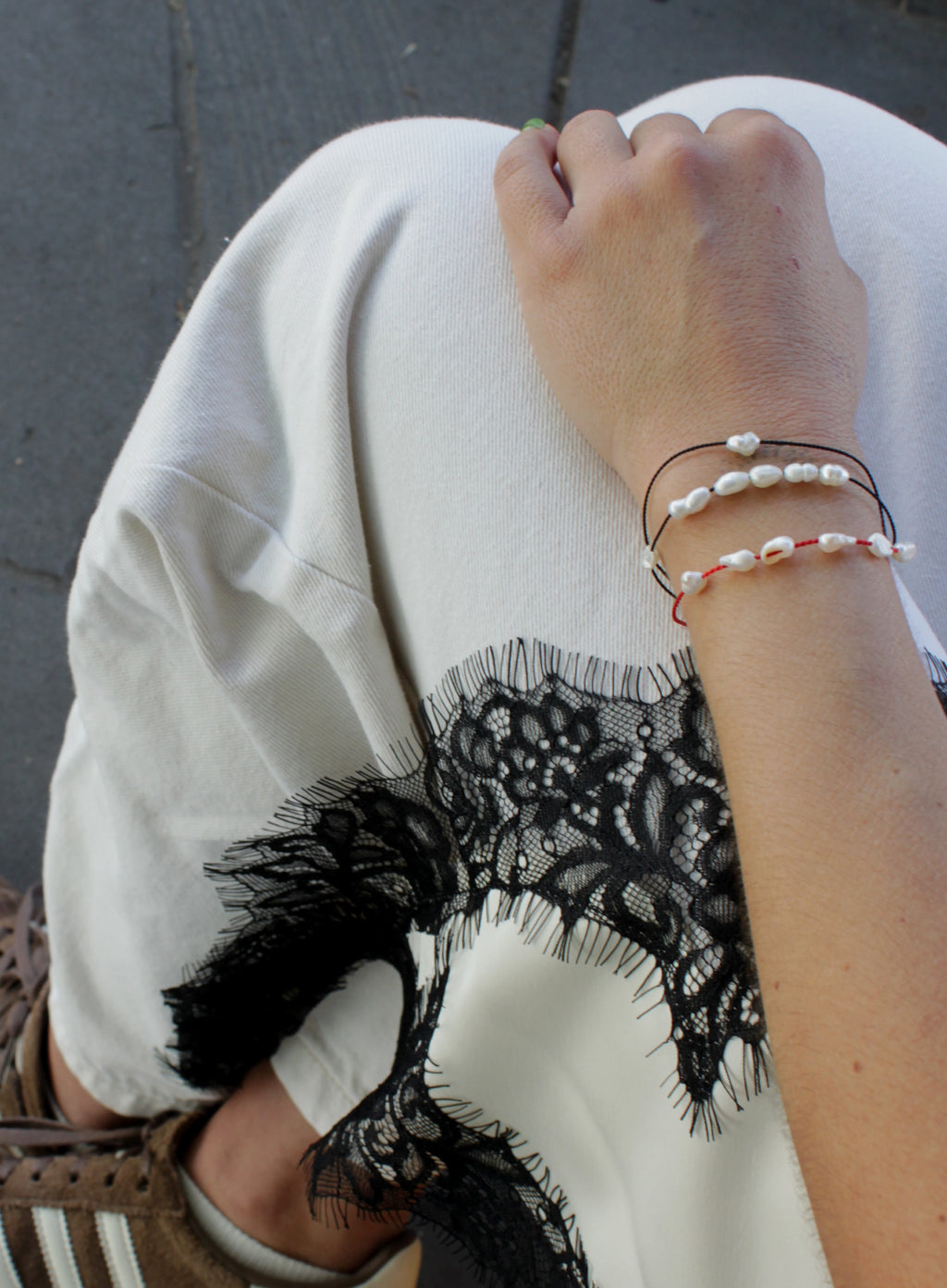 woman multiple silk cord pearls bracelets