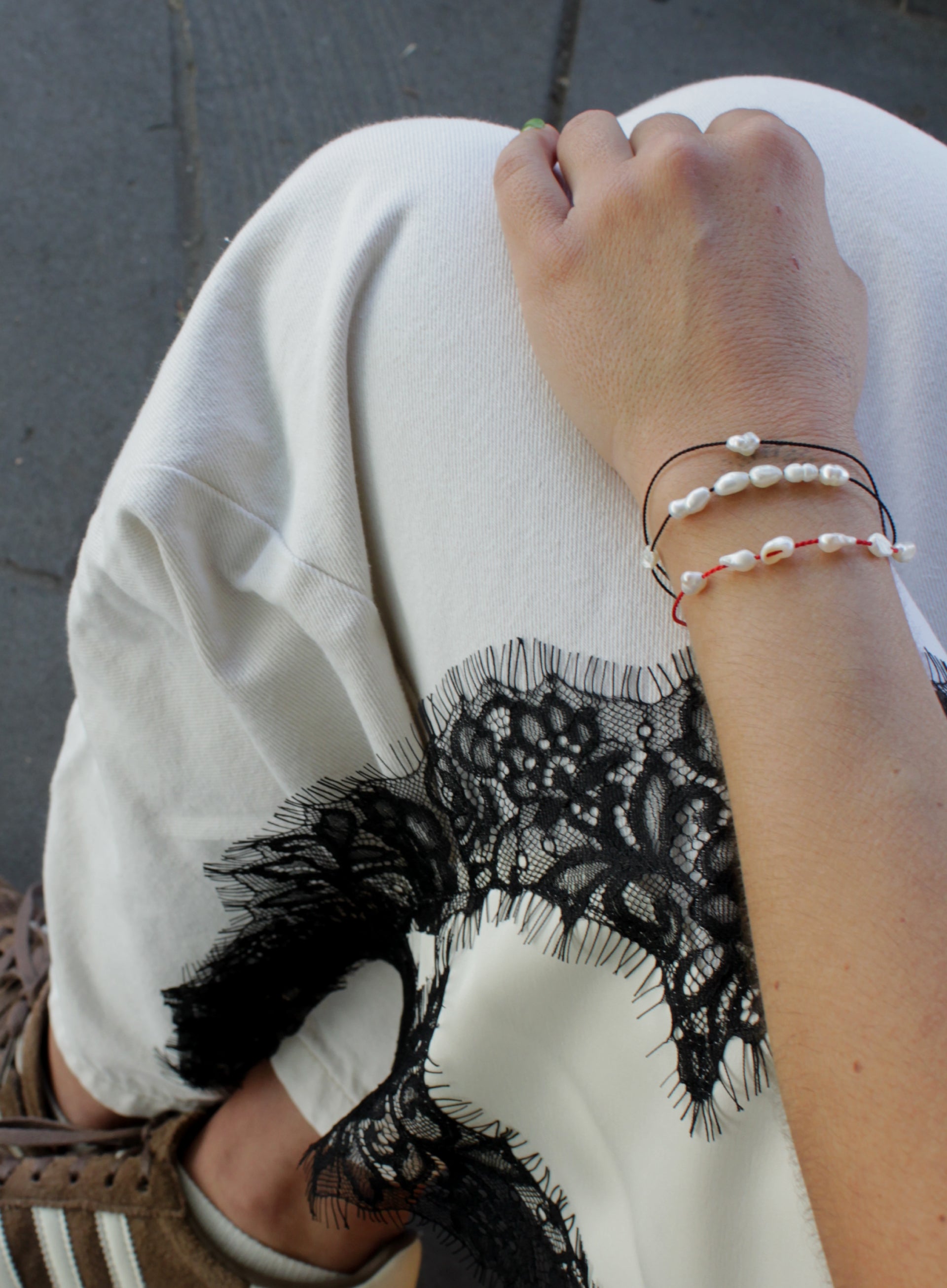 woman multiple silk cord pearls bracelets