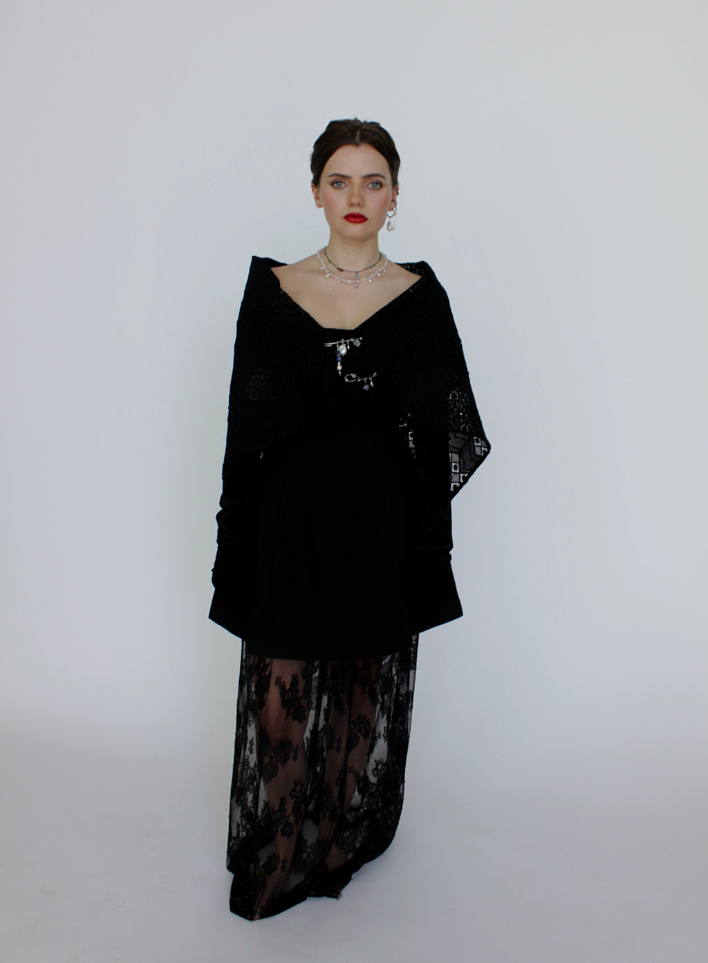 Woman wearing a black dress with sheer panels on a white background