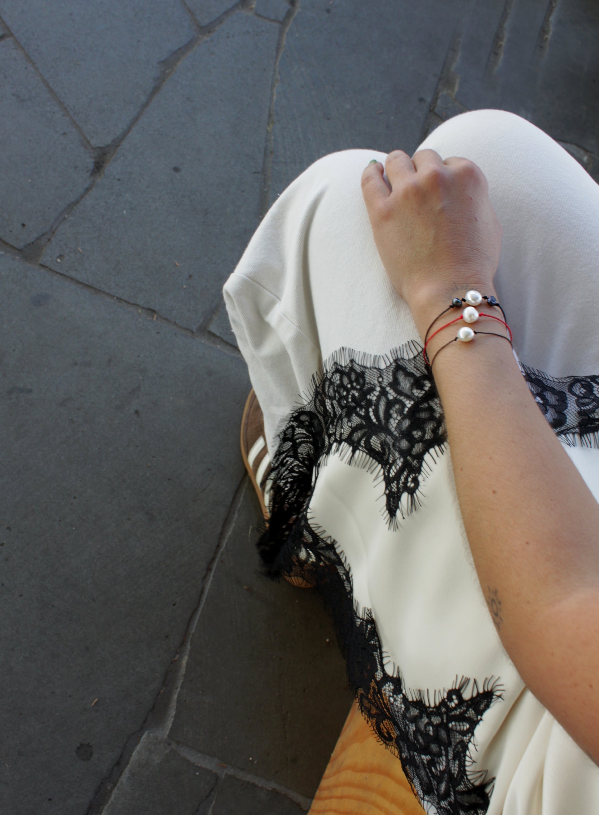 woman multiple silk cord pearls bracelets