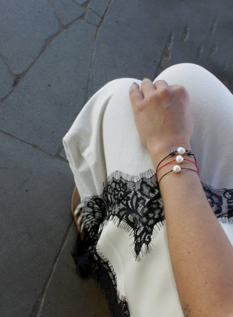 woman multiple silk cord pearls bracelets