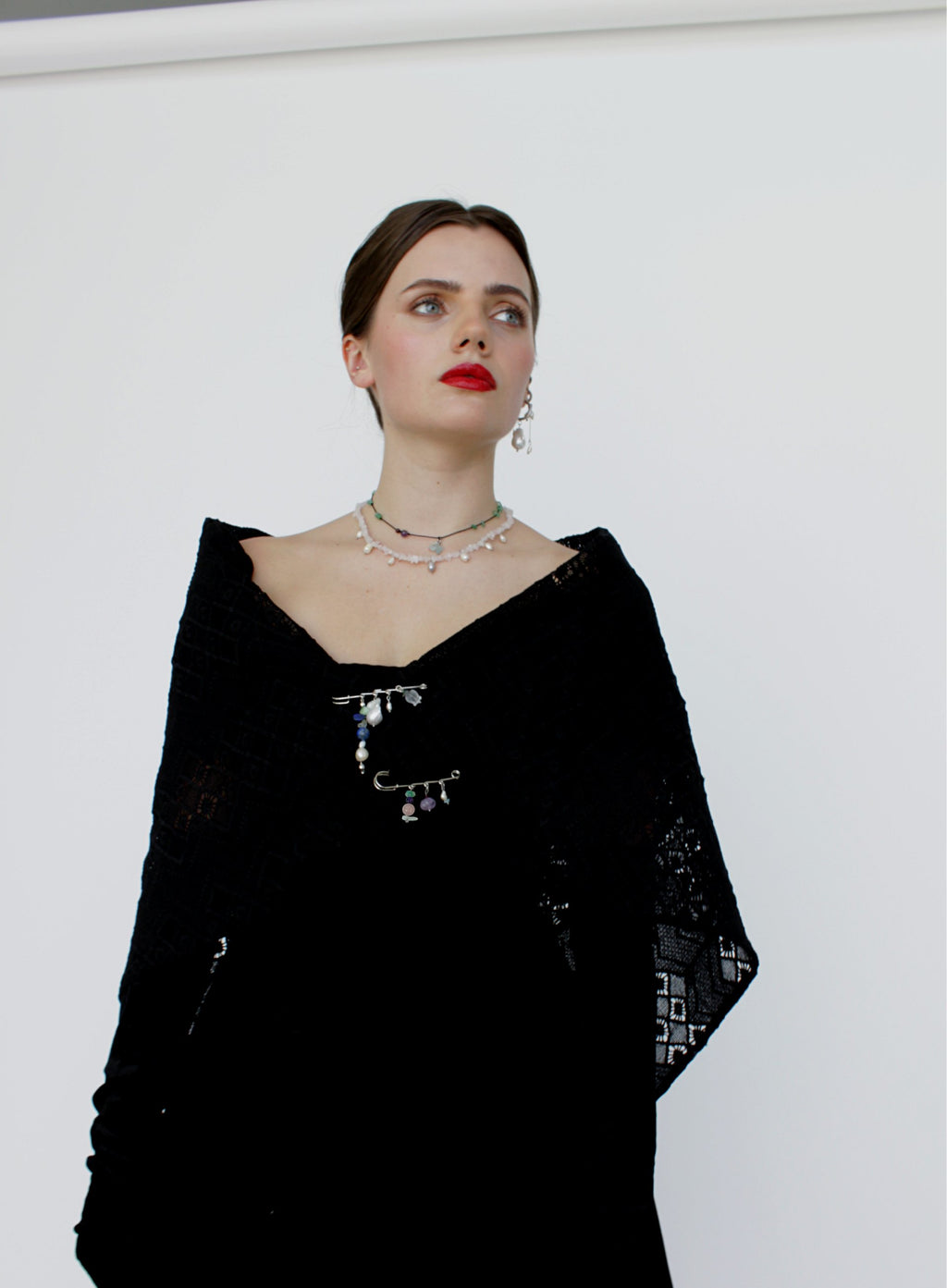 Woman wearing a black outfit with intricate designs on a white background