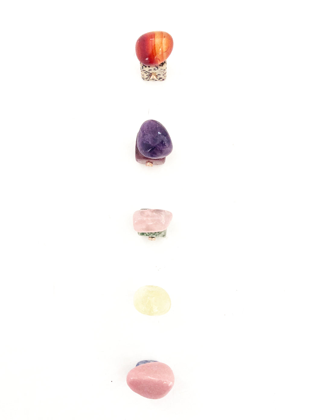 Set of colorful stone-shaped letter 'A' charms on a white background