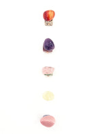 Set of colorful stone-shaped letter 'A' charms on a white background