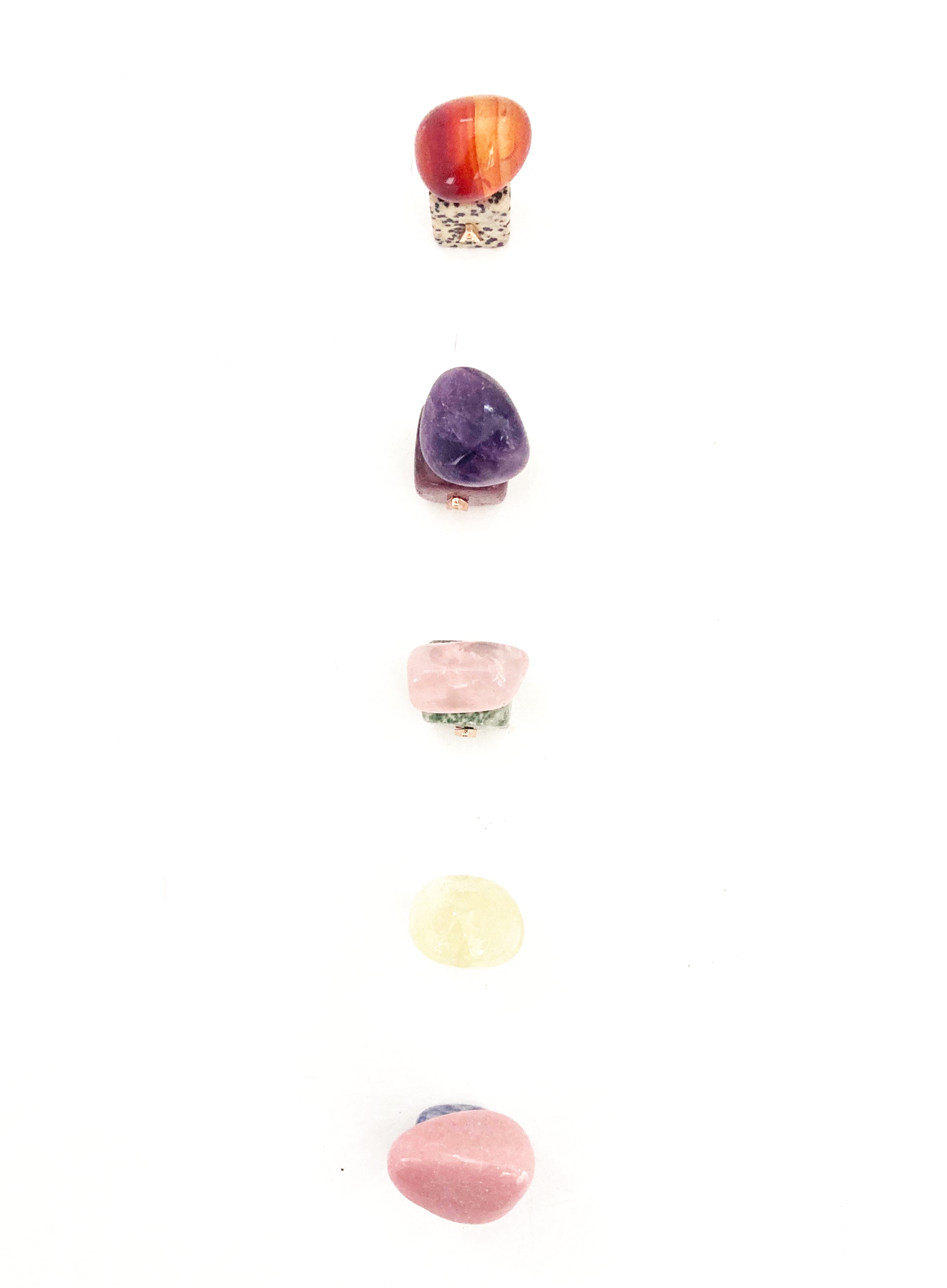 Set of colorful stone-shaped letter 'A' charms on a white background